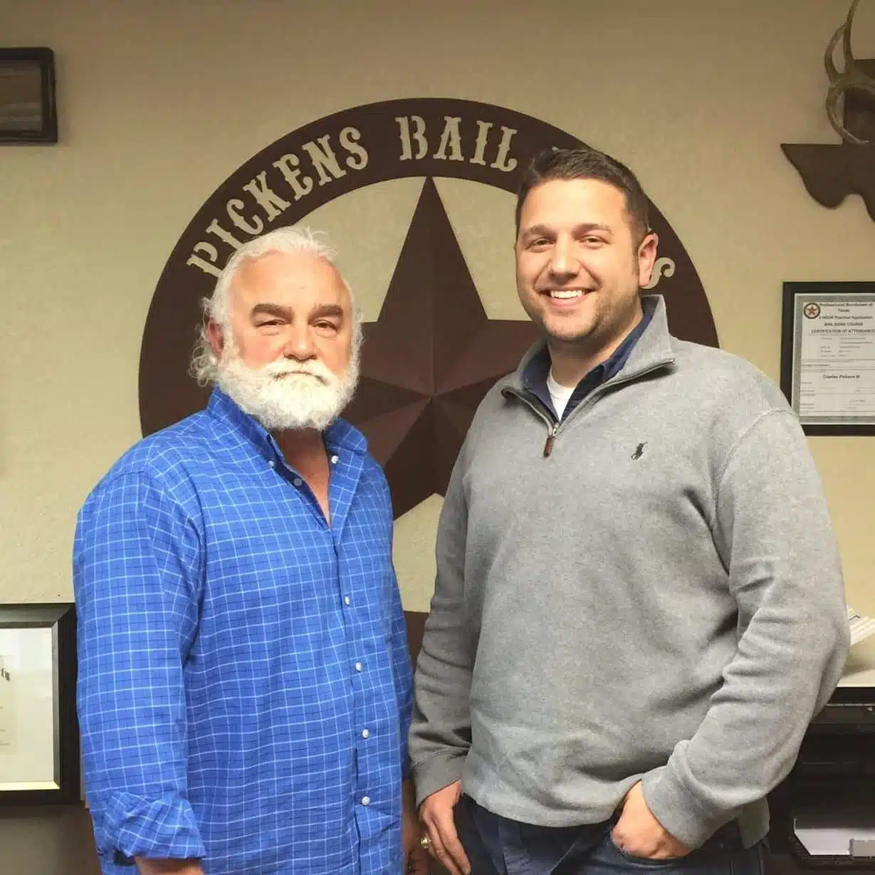 Owner and son standing in the Pickens Bail Bonds office in Waco, TX, a family-operated business dedicated to helping people in need with respect and care for over 25 years.